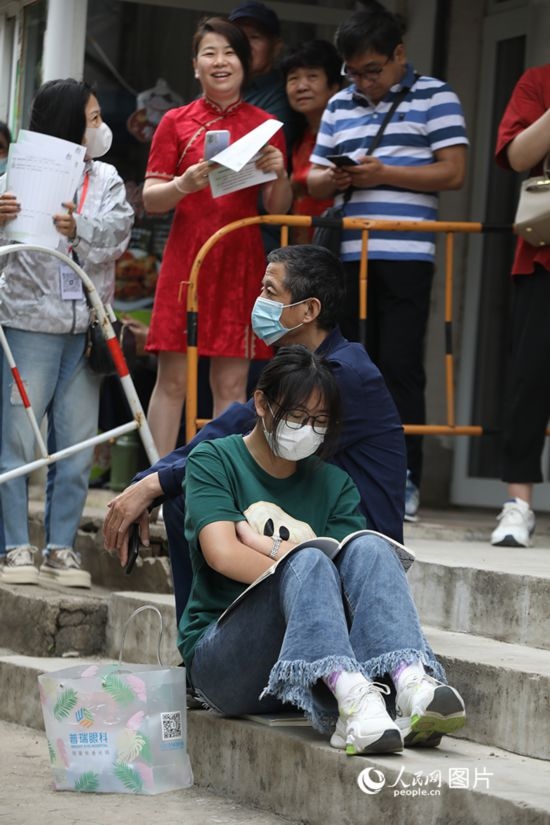 6月7日，沈陽市第一中學(xué)，學(xué)子靠在父親身邊做最后的沖刺。人民網(wǎng) 周頌雪攝