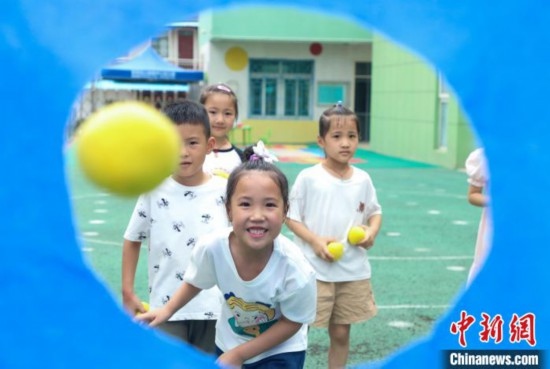 在肥西縣山南鎮(zhèn)中心幼兒園，孩子們在玩布洞投球游戲。陳家樂 攝