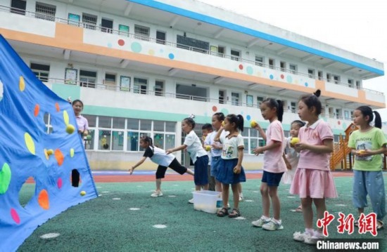 在肥西縣山南鎮(zhèn)中心幼兒園，孩子們在玩布洞投球游戲。陳家樂 攝