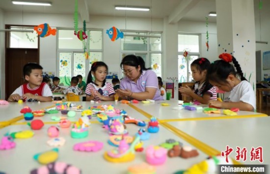 在肥西縣山南鎮(zhèn)中心幼兒園，孩子們在老師的指導(dǎo)下做彩色泥塑。陳家樂 攝