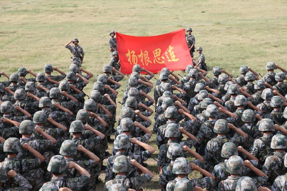 ↑“楊根思連”官兵執(zhí)行任務(wù)前向連旗宣誓（資料照片）。新華社發(fā)