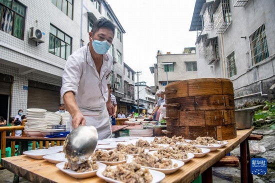 7月29日，在重慶市綦江區(qū)安穩(wěn)鎮(zhèn)，當?shù)鼐用裨凇懊缂曳蚬?jié)”上準備羊肉長桌宴。新華社記者 唐奕 攝