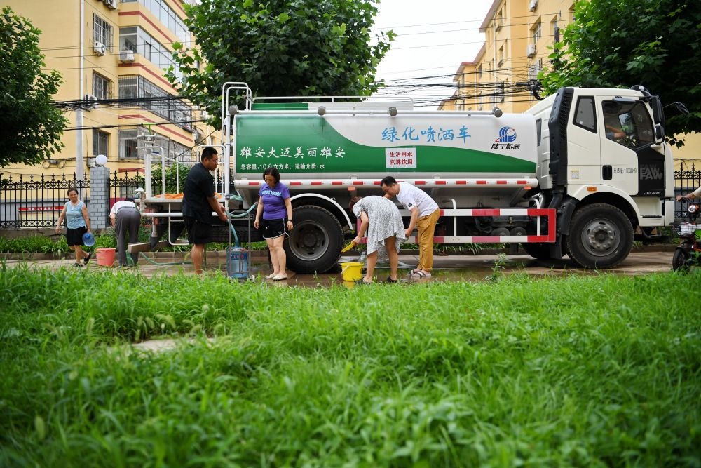 河北省涿州市新星小區(qū)居民從供水車?yán)锝铀?月4日攝）。新華社記者 牟宇 攝