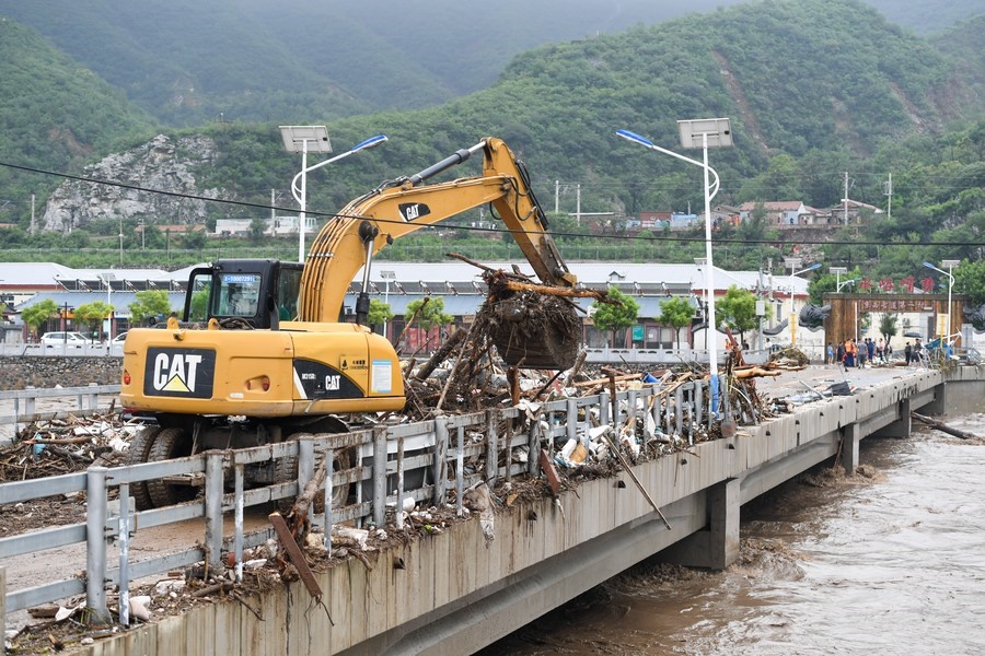 8月1日，在北京市門頭溝區(qū)水峪嘴村村口，一臺挖掘機在清理阻斷橋梁交通的雜物。目前該條道路已經(jīng)疏通完成。新華社記者 鞠煥宗 攝