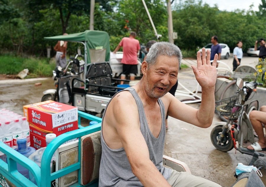 8月5日，從安置點回來的北京市房山區(qū)青龍湖鎮(zhèn)口頭村村民高大爺領到生活物資準備回家。新華社記者 張晨霖 攝