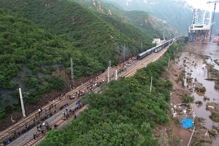 8月2日，受困列車(chē)旅客在救援人員幫助下徒步趕往轉(zhuǎn)運(yùn)客車(chē)（無(wú)人機(jī)照片）。新華社記者 張晨霖 攝