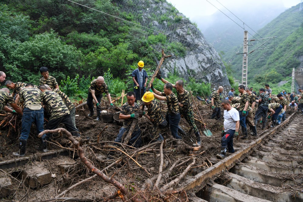 8月1日，在北京市門(mén)頭溝區(qū)水峪嘴村附近一段被阻斷的鐵路線上，中鐵六局工作人員在清理軌道上的雜物，全力恢復(fù)交通。新華社記者 鞠煥宗 攝