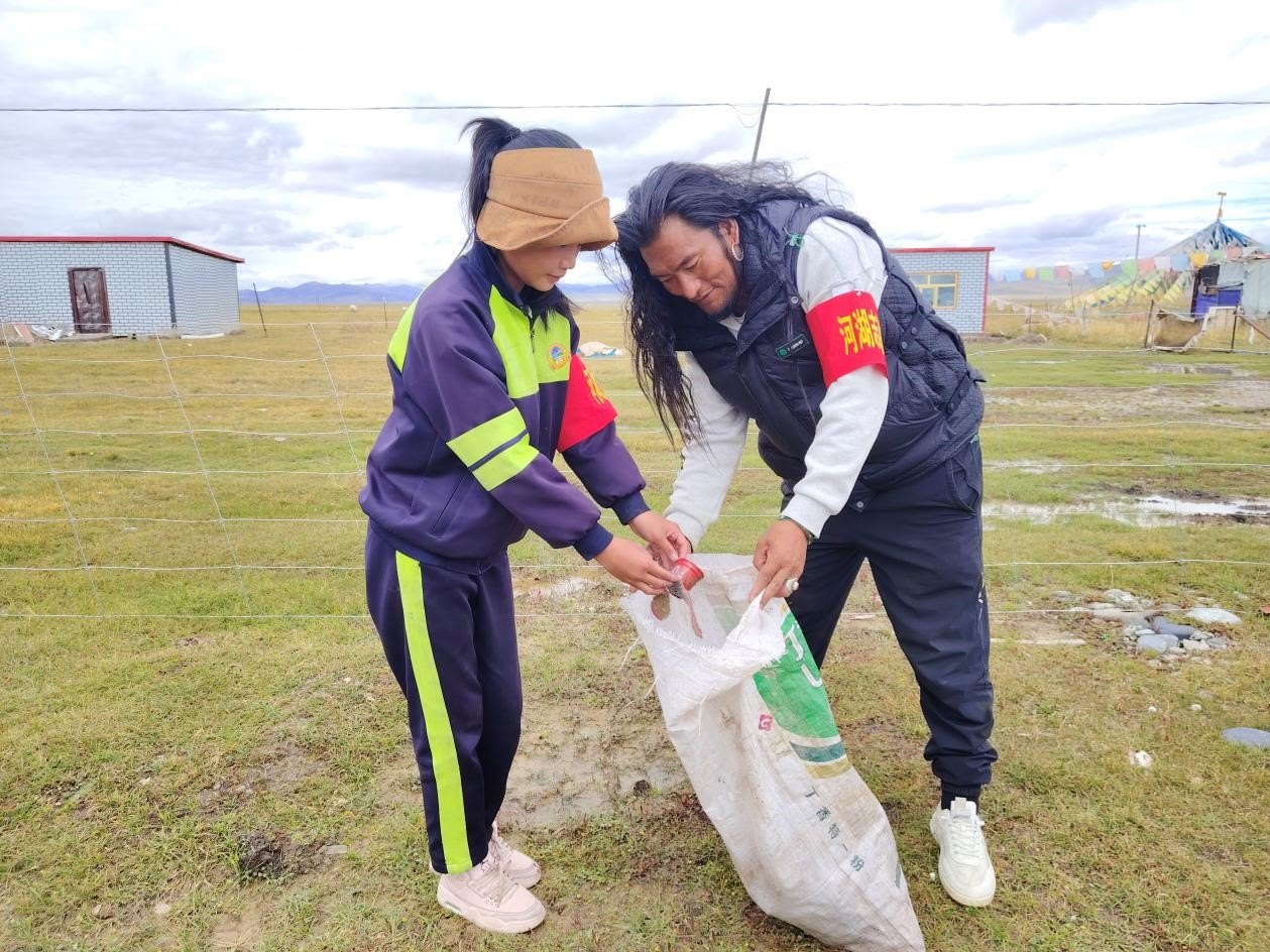 玉樹州稱多縣珍秦鎮(zhèn)河湖志愿者才培和他女兒更求拉毛在清掃垃圾。受訪者供圖