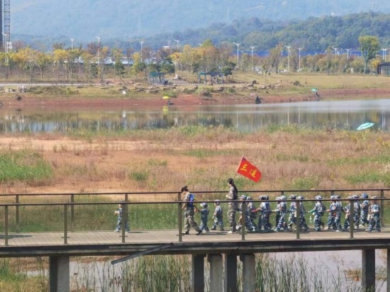 10月24日，秋游的幼兒園小朋友在老師帶領(lǐng)下走在清水塘公園里的木橋上。本報記者 常雯宜攝