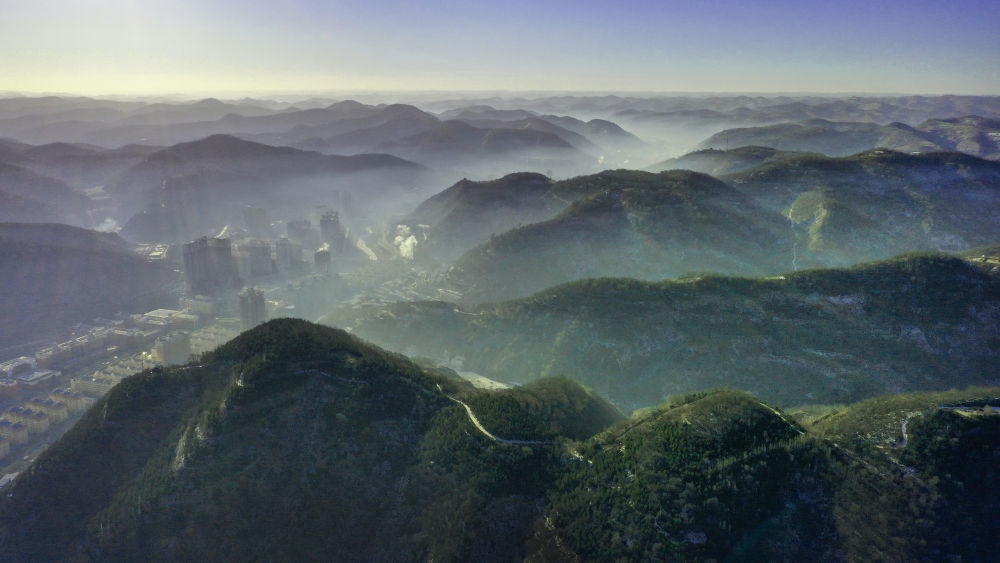 陜西省延安市吳起縣的山山峁峁被茂密的山林覆蓋（2021年12月20日攝，無(wú)人機(jī)照片）。新華社記者 陶明 攝