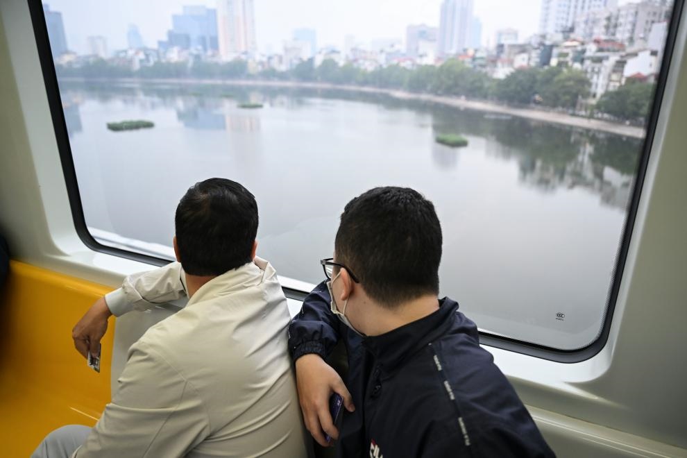 12月9日，市民在越南河內(nèi)輕軌二號線車廂內(nèi)透過車窗欣賞城市風(fēng)景。