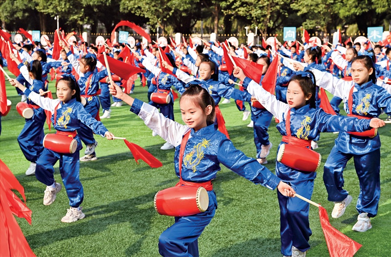 為助推民族地區(qū)基礎(chǔ)教育事業(yè)發(fā)展，廣西重新核定各地中小學(xué)教職工編制，依托全區(qū)編制“周轉(zhuǎn)池”核增事業(yè)編制給各地中小學(xué)，在全面達(dá)到國(guó)家標(biāo)準(zhǔn)的基礎(chǔ)上，進(jìn)一步統(tǒng)籌優(yōu)化和動(dòng)態(tài)調(diào)整各區(qū)域、學(xué)校、學(xué)段間編制資源。圖為2023年11月29日，南寧市濱湖路小學(xué)舉行主題為“逐夢(mèng)新時(shí)代 健體向未來(lái)”的體育文化節(jié)，孩子們正在跳腰鼓舞。 新華社記者 周華/攝