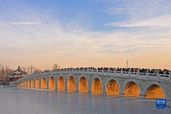 這是12月22日拍攝的頤和園十七孔橋“金光穿洞”景象。