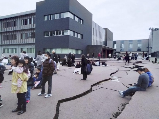  1月1日，在日本石川縣輪島市，人們站在被地震破壞的地面上。新華社/共同社