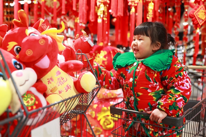 1月23日，在貴州省黔東南苗族侗族自治州岑鞏縣一家超市，小朋友在家人的帶領(lǐng)下選購龍年毛絨玩具。新華社發(fā)（唐鵬攝）