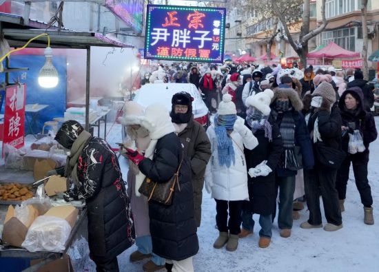 在哈爾濱紅專街早市，顧客們排起長隊(duì)購買油炸糕（1月22日攝）。新華社記者 王毓國 攝