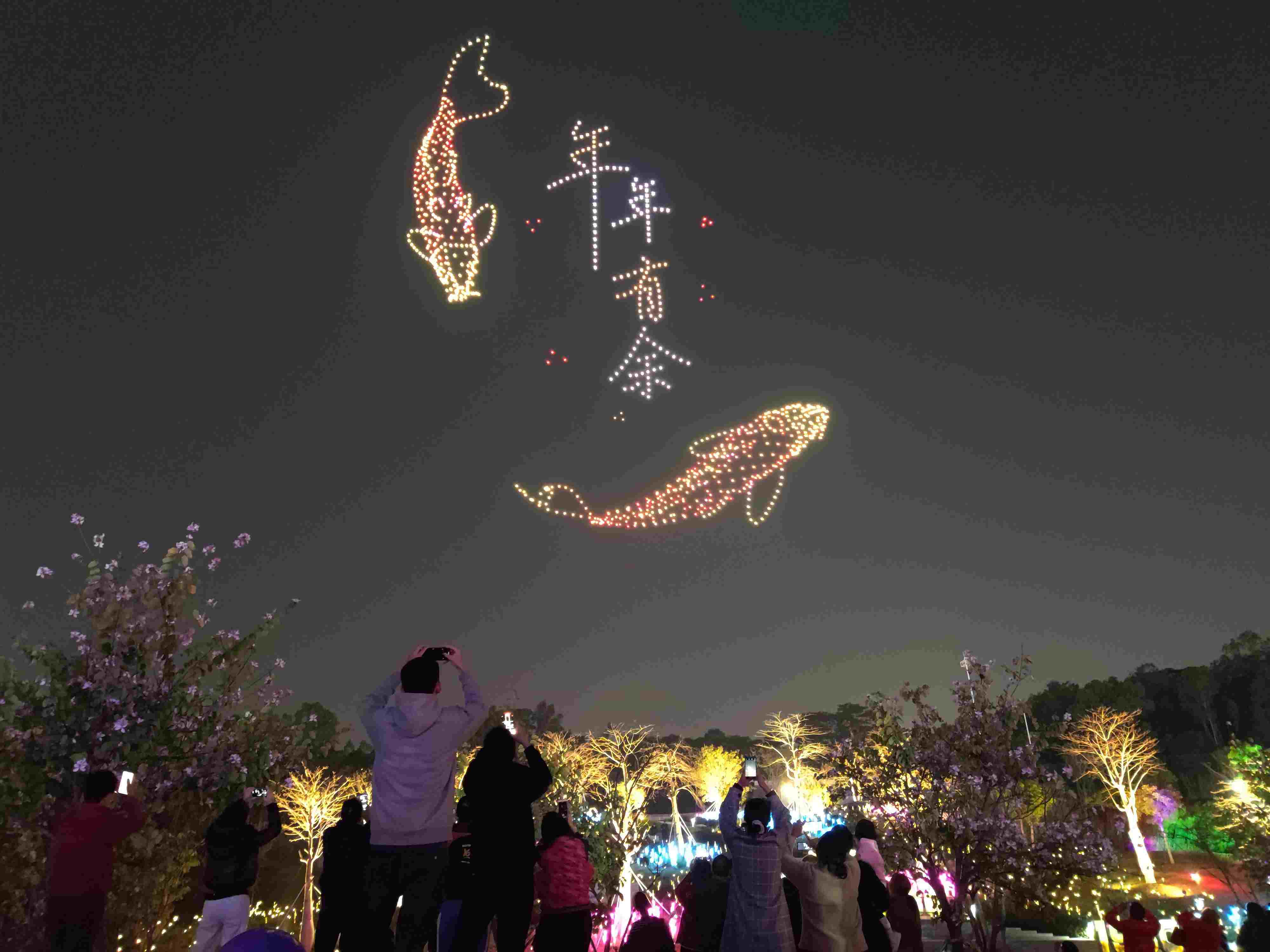 △ 2024年2月10日，深圳北站中心公園，春節(jié)主題無人機(jī)燈光秀引來眾多游客駐足觀看。