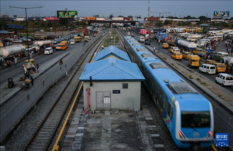 3月4日，在尼日利亞拉各斯，一列輕軌藍(lán)線列車行駛至公路交通擁堵路段附近。新華社記者 韓旭 攝