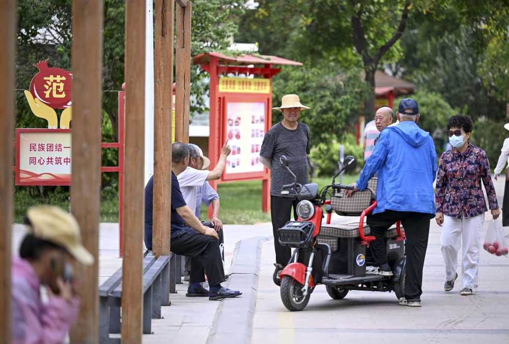 6月20日，長(zhǎng)城花園社區(qū)的居民在休閑、聊天。