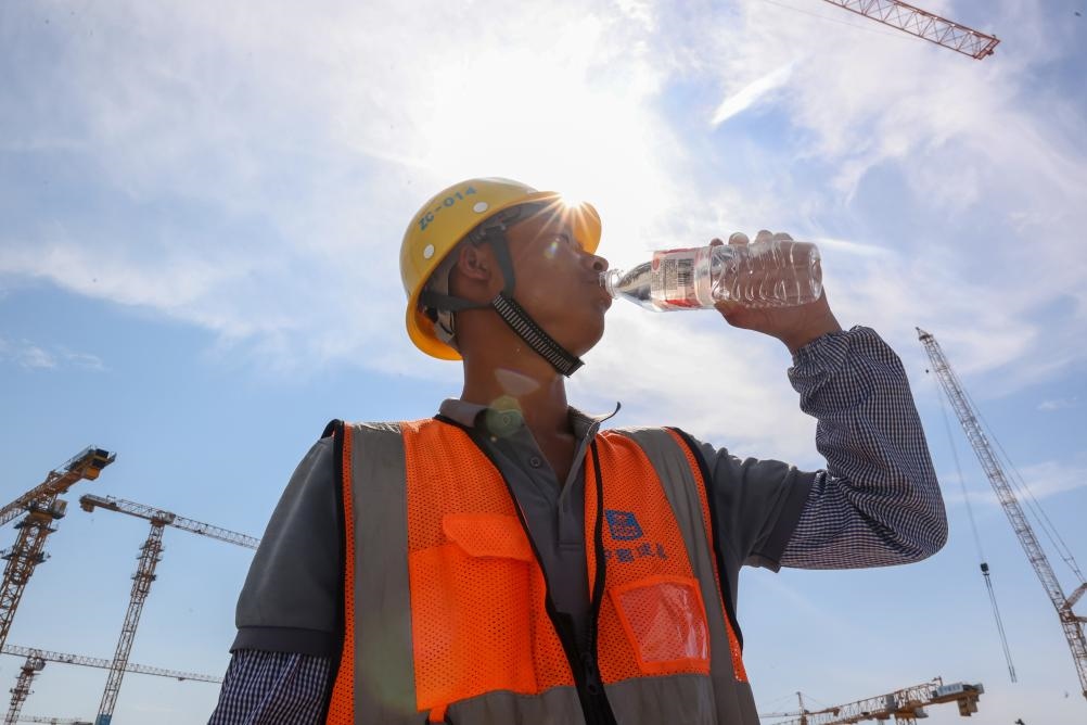 6月18日，在江蘇省無錫市奧體三期項目施工現(xiàn)場，中建二局工人在喝水解暑。新華社發(fā)（朱吉鵬 攝）