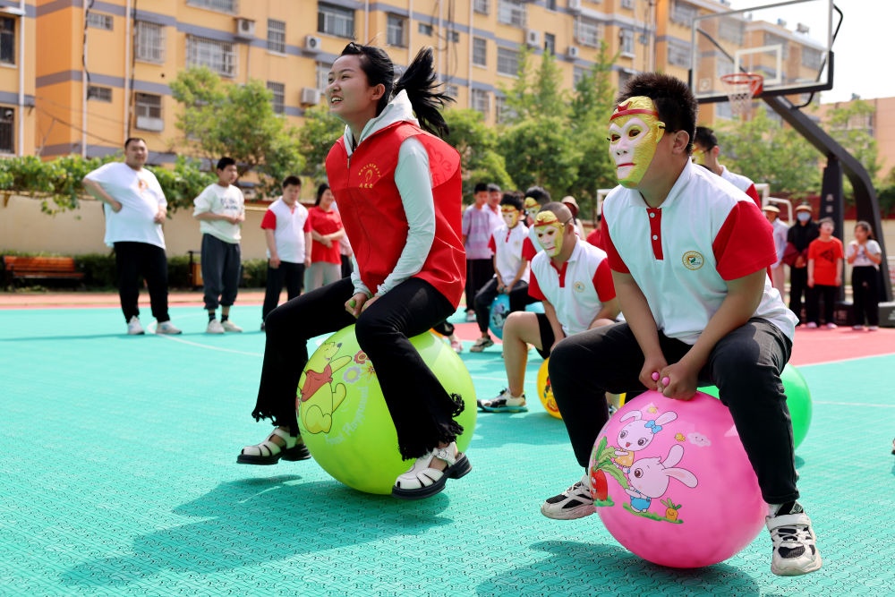 2024年5月17日，在山東省棗莊市市中區(qū)特殊教育中心，青年志愿者與智力障礙學(xué)生一起做游戲。新華社發(fā)（孫中喆攝）