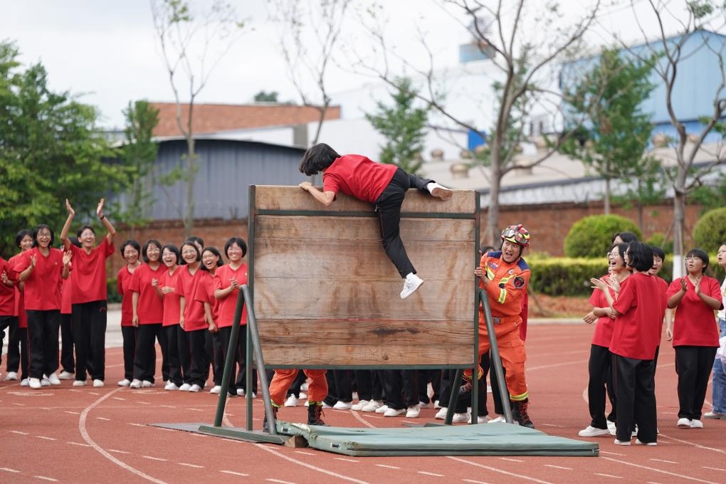 云南麗江華坪女子高級中學(xué)學(xué)生在體驗(yàn)翻越障礙板。新華社記者陳欣波 攝