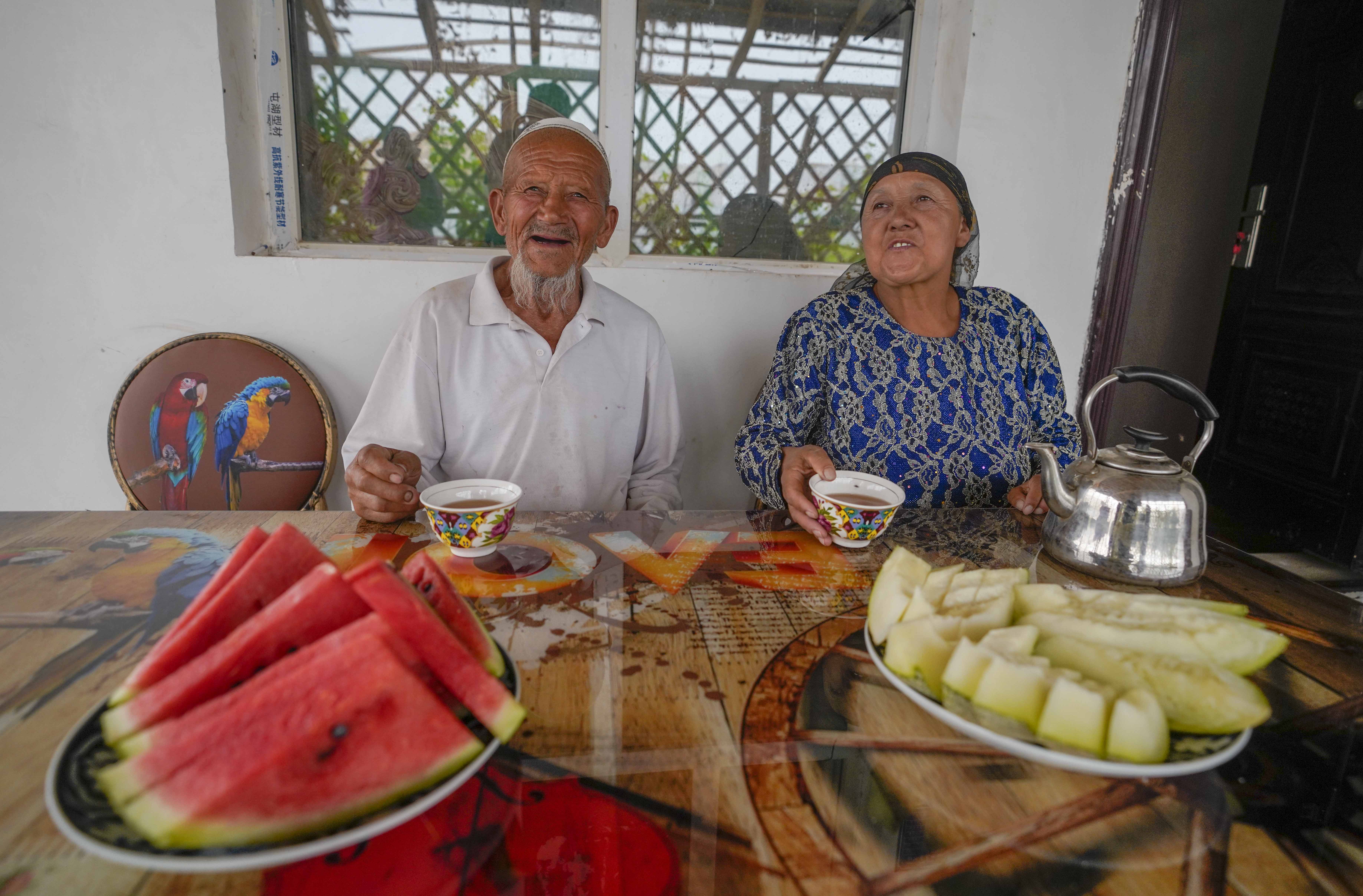 在新疆喀什地區(qū)伽師縣江巴孜鄉(xiāng)依帕克其村57號，80歲的維吾爾族老人伊米提·艾山（左）在自家庭院中（2020年6月8日攝）。