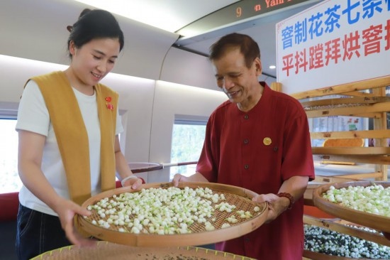 10月1日，福州市茉莉花茶窨制工藝代表性傳承人張子建與旅客在G1634次列車上制作茉莉花茶。新華社記者周義 攝