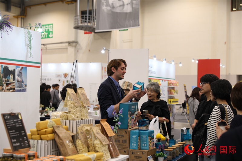 當?shù)貢r間10月5日，在第21屆釜山國際美食博覽會上，意大利展商向參觀者們介紹的意大利食品。人民網(wǎng)記者 莽九晨攝