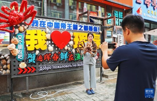 9月21日，游客在吉林省琿春市一處帝王蟹元素主題裝飾前拍照留念。新華社發(fā)