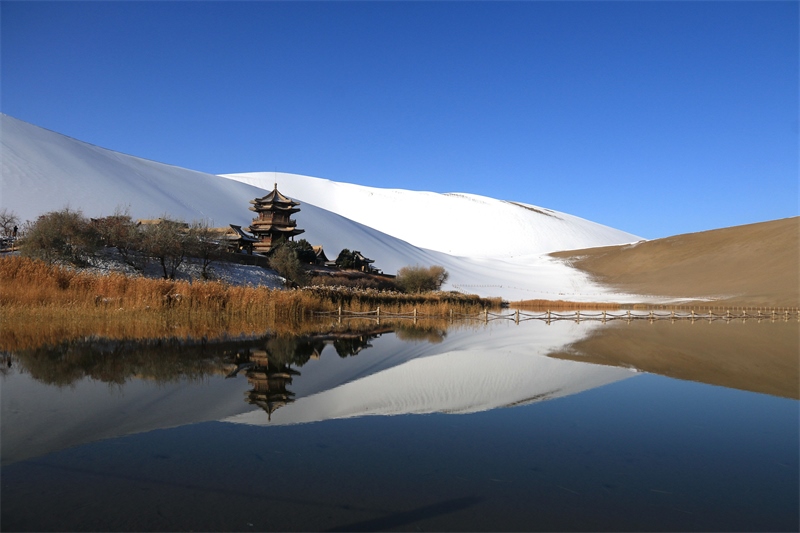 鳴沙山月牙泉景區(qū)雪景。敦煌市委宣傳部供圖，張曉亮攝