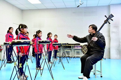 圖為12月30日，在惠民縣胡集鎮(zhèn)第一小學(xué)，老師指導(dǎo)學(xué)生學(xué)習(xí)西河大鼓。新華社記者 郭緒雷攝